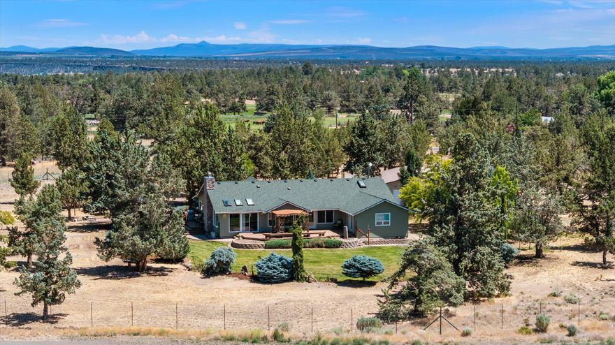 Wake up to breathtaking Cascade Mountain views in addition to Smith Rock and rolling Central Oregon pastures from your own private retreat. This 5.1-
acre property blends serene rural living with modern comforts, offering 2,638 sq ft of single-level space designed for
connection and relaxation. Soaring vaulted ceilings and expansive windows fill the home with natural light, while the chef inspired kitchen with marble countertops, custom cabinetry, an amazing walk-in butler's pantry with stainless steel appliances—flows seamlessly into a warm, inviting great room. Unwind on the wraparound porch or deck and take in the peace of your surroundings. The oversized detached garage includes a workshop and separate office—perfect for hobbies or remote work. With 3.5 acres fully fenced and gated with 7-foot deer fencing to protect your landscaped oasis, this is a rare
opportunity to enjoy privacy, space, and unforgettable views—just 15 minutes from downtown Redmond.