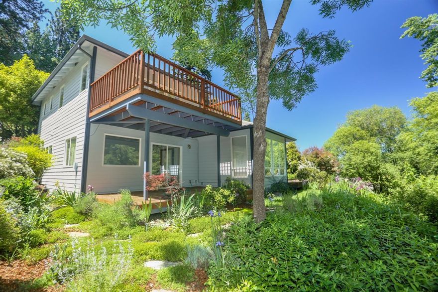 Beautiful newer contemporary home above the university enjoys varied natural light from abundant glass including clerestory windows and skylights. The home has considerable vaulting in the main living area and seamless access to the outdoor living space. The upper floor is solely reserved for the owner's personal suite with a private deck overlooking the creek and protected Roca Canyon views. The suite also has a double vanity sink, walk-in closet and a shower. The entry has an oversize garage and laundry room. The main level includes a kitchen with bay windows, living room, family room, double-sided gas fireplace, two bedrooms, a full bath, and two well-sized decks. This architecturally designed home with open floor plan maximizes its natural setting with extensive decking connecting one easily to the private 2.26 acre Roca Canyon Greenway. This well appointed move-in ready home is framed perfectly by the mature landscaping which provides serenity and a calming sense of privacy.