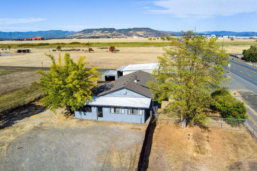 Need lots of space for RV parking and projects? This property has so much to offer like a garage/workshop, a 2-bay shop and another workshop behind that.  Property is on a well and city sewer. Home's exterior and trim was recently painted.  Roof on home is about 4 years old. Wonderful natural light flows through this home. New vinyl in bathroom and entry. Beautiful custom wood wall in living room plus wood built- ins on opposing wall. Home includes a pellet stove for toasty winter nights. Kitchen has custom cabinetry and a serving window! Lots of counter space, eating bar and an appliance garage! Family room/dining room windows look out to the fields and mountains.  Laundry room is so large it could also be used for office space. Fully fenced with a solar powered gate and a manual gate on the shop side. Beautiful views of the table rock mountains and surroundings.
