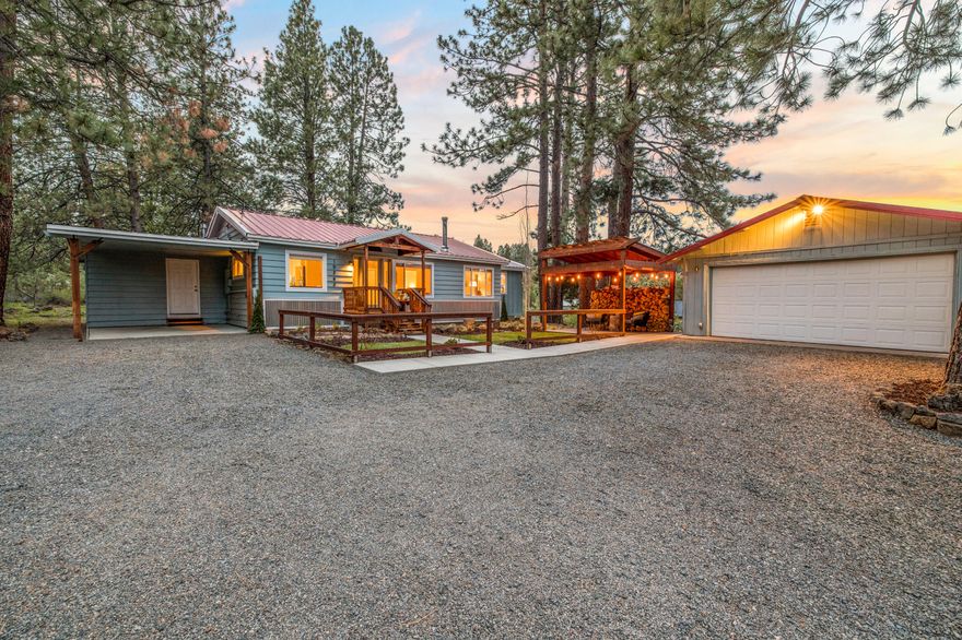 Enjoy country living on this rare 1.95 acre corner lot with Irrigation water rights supplying a 10,000 gallon cistern & seasonal pond.  Mature trees surround the property attracting wildlife & keeping the house cool in the summer.  This updated single level home boasts numerous windows allowing views of the pines and plenty of natural light.  An ample sized laundry room/mudroom stores all your seasonal gear. Other interior features: stainless appliances, newer carpets & certified wood stove. Entertain in one of the multiple outdoor living spaces.  Relax by the pond & soak up the starlit nights by the fire. Detached 2 car garage features a finished 400 sq ft bonus room that could be your new home office, playroom, workout or family room.  Other amenities include RV Parking, 50 amp RV Hook up, outdoor fire pit, storage shed & plenty of room for all your animals!  This beautifully maintained property has it all! See attached 3D Matterport tour to virtually experience this unique property!