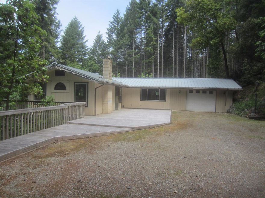 Cute country home on just over 2 acres. Spacious family area, cute kitchen with tile flooring & some appliances. Dining area has french doors out to deck. Large wrap around deck for great views and entertaining.