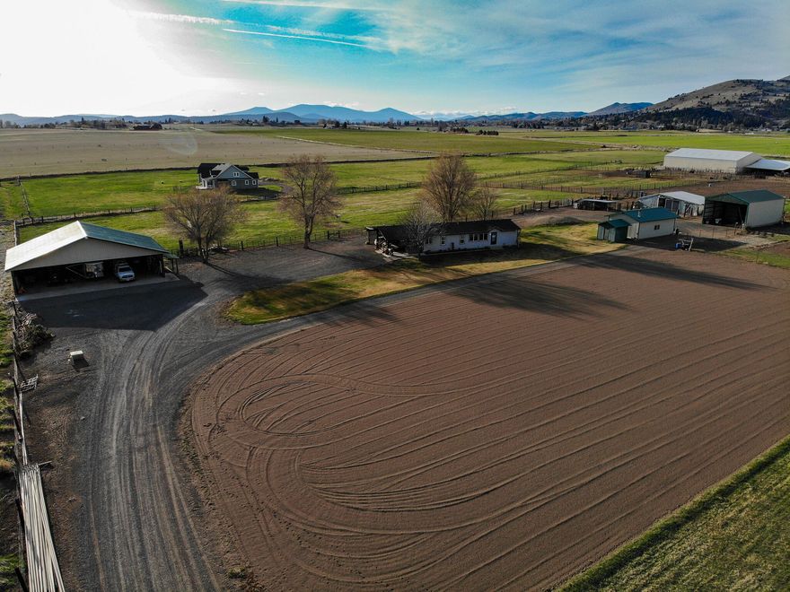Dreams really do come true! Don't miss out on this 9-acre farm/ranch. Enjoy the 130x260 sandy arena! Grow your own hay, vegetables, fruits, raise your own chickens/eggs, and cattle. Fruit trees include peach, nectarine, apple, and pear. This property has a horse/cattle barn with 4 stalls, a tack room with refrigerator, a full 220, and a built-in work bench, set up for a perfect hobby shop. Another 40x60 metal building with a concrete floor to park your cars, trucks, trailers, and farm equipment. Enjoy the sunrise or sunset from the hot tub or the spacious deck. Updates include a new roof and exterior paint in 2021, a new heat pump in June 2021, the septic replaced in the fall of 2021, and a recently repainted interior. Covered chicken coop and dog kennels stay with the property. Irrigation power was less than $1000 in 2021, all irrigation equipment included. The sellers will provide a $10,000 credit at closing to be used for closing costs or buyer can use to buy down points.