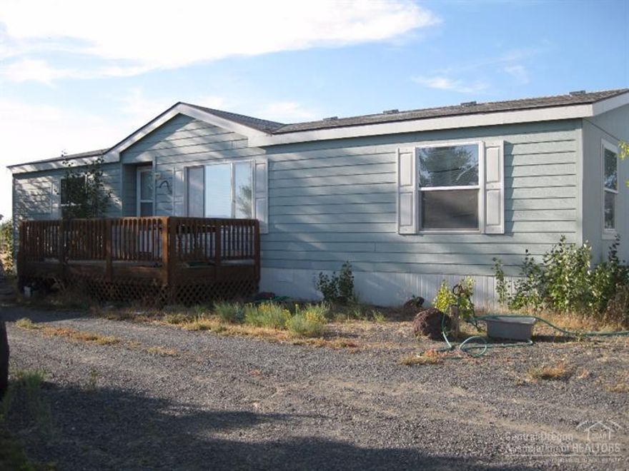 Nice country home on just under 5 acres of land with a huge shop where you can park your cars and RV plus an open carport side as well. Home is 3 br/2 bath with a nice front & back porch too. Property has some trees, landscaping & circle driveway on APROX 4.80 ac. Enjoy the distant views of the mountains, some great sunrises and sunsets in the wide open spaces of the high desert. Buyer to do their due diligence. Great price too!