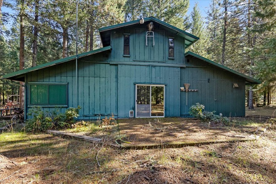Looking for peace & tranquility? Look no further. This Big American Barn Style home is tucked in the forested treed 6.39 acres. Inside has 3 bdrm 2 bath, living room, kitchen with corner windows that over look the beauty of the trees, mirrored storage space, stainless sink, new gas oven/range, upper ranch cabinets & sliding barn doors. The lower level also has a covered patio to enjoy your morning coffee. Upstairs is a Bthrm & open space for 2 bdrms or 1 large room, plus a large covered deck for your enjoyment. Outside is a sturdy insulated laundry & pump house shed & attached Canning room. There's a large propane tank in the backyard, plus RV site with electric hookup, water & dump site. The attached garage is also a shop that's insulated & drywall & notice the lifetime metal roof! The style & feel of this home is Country, Comfy, Comfortable with plenty of room for children to play, garden for flower/veggies, animals & all enclosed in chain link fence that surrounds the whole 6.39ac