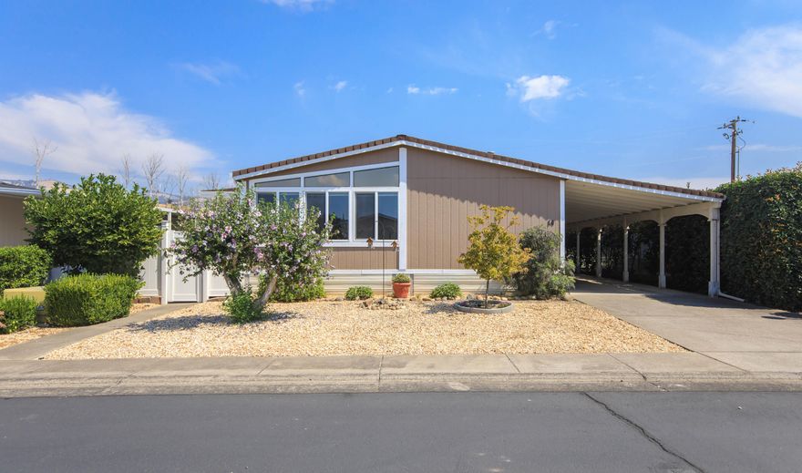 Turnkey 3 bed, 2 bath home in Greenway Village, a quiet 55+ community in South Phoenix. This spacious 1,782 sq ft home features a new roof (2024), Energy Star windows (2025), exterior paint (2022), vinyl plank flooring throughout, and updated bathroom vinyl. The light-filled kitchen offers ample cabinetry, large kitchen island, a built-in desk that makes a great office space, and a dining area off the kitchen for entertaining. All appliances included—plus a second fridge and washer/dryer in laundry room. Outside, enjoy the flowers and plants including Rose of Sharon, grapes, rosemary, and Cypress. The fully fenced yard has an Orbit sprinkler system and backs to peaceful farmland. Additional features include a shed with workbench, carport ramp, and newer vinyl fencing and gate. Well-maintained and move-in ready, this home offers low-maintenance living in a welcoming park near shopping, dining, and access to the Bear Creek Greenway for walking and biking.