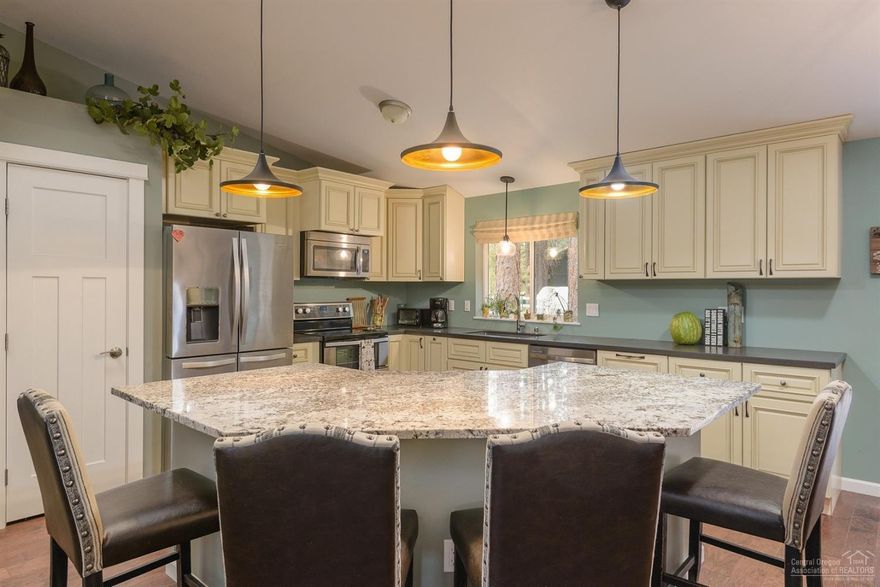 Peaceful & private, this exceptional single level home is sited amongst the Ponderosas, on a flat .49 acre. The open great room has a vaulted ceiling with skylights & a contemporary style free standing gas fireplace. Chef's kitchen features a large island with slab granite, quartz countertops & stainless steel appliances. The home has 4 large bedrooms (one of which is currently used as an office), 2 bathrooms, plus a powder room & laundry. Built in 2016, the home has many upgrades including wood flooring, designer paint & window coverings, radiant heated floors in 2 bathrooms, solar tubes, central AC/heat, & central vac. Appliances are included. The 2-car garage is attached; RV parking has hook-ups. Large rear deck is accessed from the dining area ; natural landscaping allows for carefree living. The home is located across the street from the Deschutes River, close to the neighborhood access & boat ramp. Located just south of Sunriver, close to Bend & many recreational opportunities.