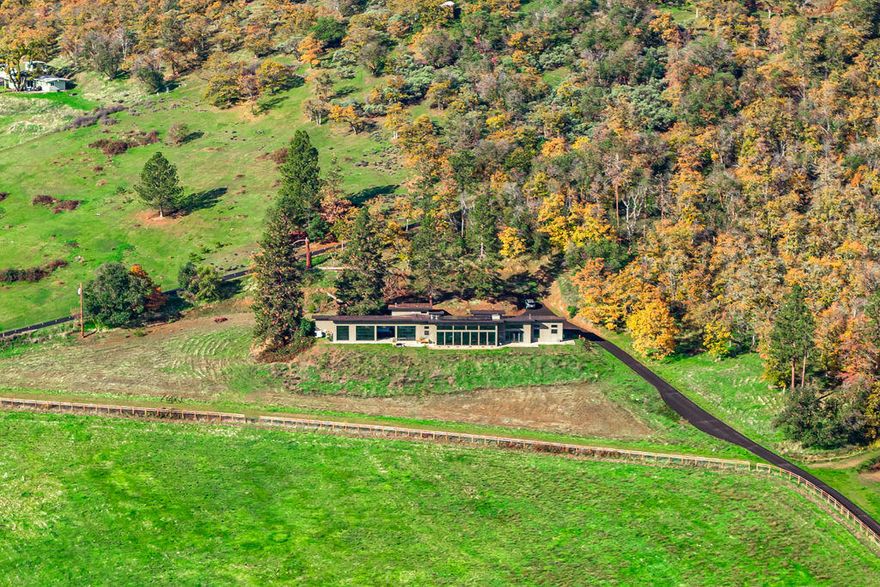 ''The Cloud 9 Ranch'' on 40 acres, 20 acres irrigated through TID, gently sloping pastures, w/South Easterly exposure, 2 barns & 2 newer 2500 SQ FT Greenhouses.  Electric gated entry w/white vinyl fencing, paved driveway. Fully fenced & cross fenced.  Main home is very modern w/3bdrm, 3.5 baths, 5016 SQ FT w/high end finishes & amenities. Open lg living w/16' vaulted ceilings w/floor to ceiling windows overlooking the valley, orchards & vineyards. Cherry wood floors, great rm w/efficient Rumsford wood burning fireplace w/floating mantel. Kitchen w/Wolfe 6 gas burner w/grill, Quartz & Stainless counters, custom cabinetry, lg island, built in fridge & 2 dishwashers. Master suite w/lg walk in closet, custom tile shower, soaking tub & fireplace. Heated Indoor salt water pool, waterfall w/3 floor to ceiling glass doors overlooking the views. 2 separate office/hobby rms. 2-360 SQ FT cabins w/bathrooms. Original Farm house 3/1, 1440 SQ FT (permitted for storage per county)