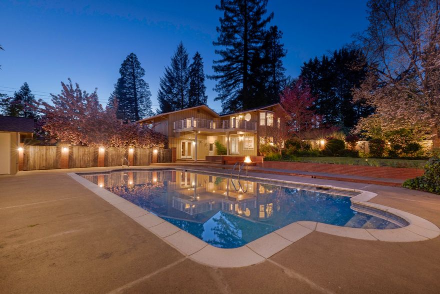 This private 3-acre estate features a custom home, attached garage, tranquil pond, year-round creek, and a spacious detached shop and garage. The property consists of three individual 1-acre tax lots with flexible R-1-6 zoning, creating meaningful development potential. The 3,951 square foot residence includes vaulted ceilings, tile countertops, a Sub Zero refrigerator and freezer, and custom oak cabinetry with pull outs. The primary suite offers a quiet retreat with a mini split, soaking tub, walk in shower, dual vanities, and French doors that open to a private deck. Along with the attached two car garage, the detached three car garage adds a full bath and versatile hobby or workshop space. The landscaped grounds showcase a heated in ground pool, poolside changing room, built in gas fire pit, water rights, and gated side access. Set in a peaceful, park like setting, this property offers privacy, space, and notable potential.