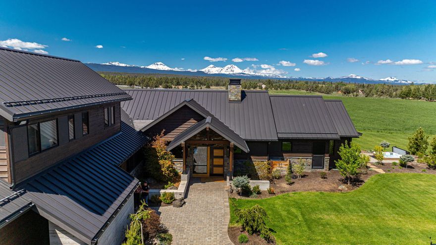 In the heart of Tumalo, a meticulously crafted 2019 estate by SunWest Builders & Architect Neal Huston spans 5,086SF featuring 5 beds/4.5 baths. Set on 20 EFU-zoned acres & 15 acres of Tumalo Irrigation. Enjoy the attached 1,969SF garage w/dog wash & storage, detached 3 garage bay/flex space, 9,000SF RV/equipment shop w/full bath & radiant heated flooring. This exquisite living experience has a state of the art chef's kitchen w/16ft island, 2 grand fireplaces, office, versatile game/flex room, luxurious practicality extends to mudroom, walk-in pantry, wet bar, a primary wing w/dual closets & steam shower. Live outdoors w/a spectacular living/kitchen area boasting a pizza oven, smoker, bbq, fridge, 3rd fireplace, TV & overhead heaters. More fun to be had in the greenhouse, orchard, dog run, chicken coop & hot tub area. High ceilings, elegant finishes & eco-friendly amenities is the epitome of luxury. This location exudes tranquility w/ private road access & stunning Cascade Mtn. Views!