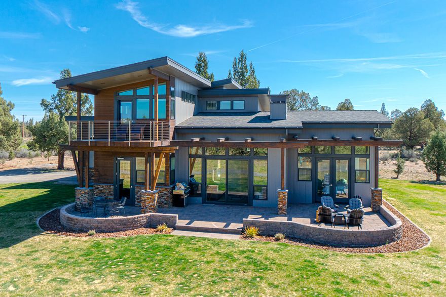 Beautiful exceptionally designed custom home on almost 10 acres backed to BLM land within 10 minutes of town with Mountain views from the home. It is a rarity to have a modern design on such a private acreage lot in Bend. Home is spectacular with an extensive use of floor to ceiling windows bringing the outdoors in. Radiant floor heat and super efficient ductless cooling and heat. Custom cabinets, hand trowled finish on walls, custom head board in master with builtins though out the home. The garage has extensive built in cabinets and a propane heater. You will love the custom cabinets, walnut chopping block bar in the kitchen and custom tile work through out. Enjoy the outdoor hot tub that has an additional heating unit located above for those cold days. The property has a RV hook up, electric, water and dump site  located at the  storage building/dog kennel and run. Tiny home built to match the home is a functioning office/studio and is included in sale.