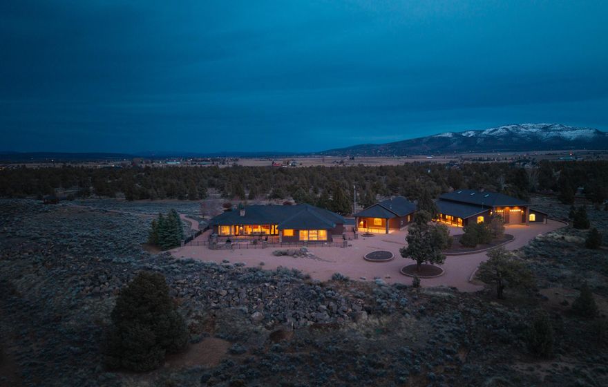 Welcome to this magnificent estate in West Powell Butte Estates, featuring a stunning 4,464sf single-story home on 20 acres of natural beauty. The property includes impressive auxiliary buildings, like the large southern facility (80' x 80') w/6 oversized garage doors, perfect for collector cars and RVs, & a central facility (36' x 60') featuring multiple extra-large doors and a convenient full bath. The home boasts 3 spacious bedrooms, each with an ensuite bath, & a luxurious game room w/a custom-built pool table & bar. The gourmet kitchen is equipped w/a Viking cooktop & modern appliances, flowing seamlessly into the open living areas. Outside, enjoy exquisite paver stone walkways & patios, complemented by elegant wrought iron details. A captivating pond, beautifully landscaped & stocked w/Koi, features a charming water feature that enhances the serene outdoor ambiance. Experience breathtaking views & unparalleled privacy, making this estate a true retreat where luxury meets nature.