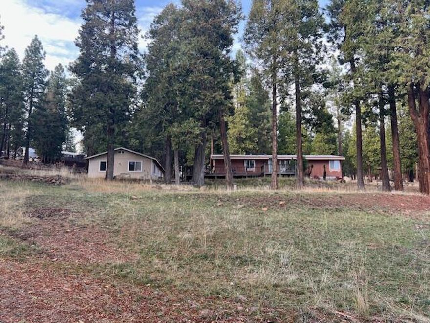 Enjoy the view from your large deck on 1.55 acres in the pines. Nice 1996 Fuqua manufactured home featuring 3 bedroom and 2 baths, vaulted ceilings and a large detached 2 car garage.