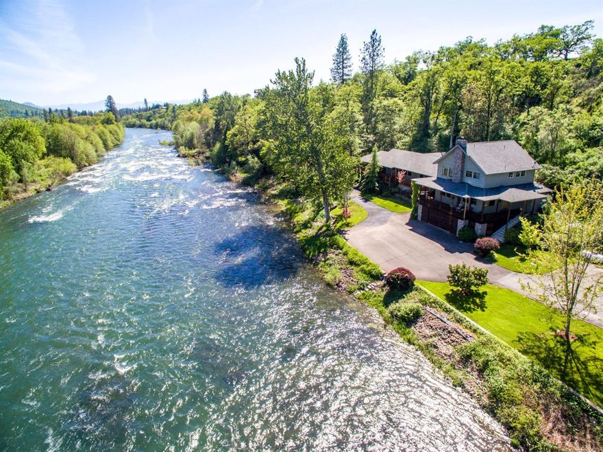 Located at the top of SALMON ALLEY - a famous Rogue River salmon fishing hole. This amazing setting will impress everyone! The lodge style home is located at the end of a long backtop driveway through nature conservancy ground ending up on the banks of the Rogue River. Home sits close to the river to enjoy white water sounds and views. Home is tastefully remodeled and added on to in 2005. Quality throughout including hardwood floors, river rock fireplace, library/game room with wet bar, large master suite on main level with master bath featuring a steam shower, sauna and Jacuzzi tub. 2,000 +/- Covered decks with hot tub, back porch with propane BBQ hook-up. Two bedrooms upstairs including a second master suite. Attached 2-car garage, detached 3-car garage, 2-carports, RV parking w/dump. 4.54-Acres, 640-ft of Rogue frontage, boat ramp, fish pond, beautiful landscaping and much more! A very unique and one of a kind property on the Rogue. OWNERS ARE MOTIVATED!