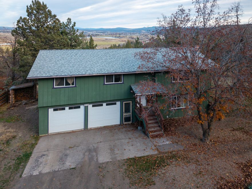 Nicely updated 4 bed, 3bath home on 1.39 acres of gently sloping land with panoramic northly views of the Ochocos and The Crooked River. The home was updated throughout in 2016 and has a ductless heat pump system with AC, featuring a head upstairs and down allowing perfect temperatures throughout the home. The great room upstairs has fantastic views that lead to an elevated deck off the dining area. Kitchen activities are enhanced by the tile counters, upgraded appliances, and the tile counters. The primary suite is spacious & has a well laid-out bathroom. Both upstairs bedrooms share a spacious guest bath with tub/shower combination. Downstairs there is a large bonus room w/wood stove, a generous bedroom with view, and a third full bath. The downstairs leads to an oversized garage w/shop space & work benches. There's RV parking right next to the house and ample room for fenced areas and vehicles/equipment. This property offers value and functionality that is tough to beat!