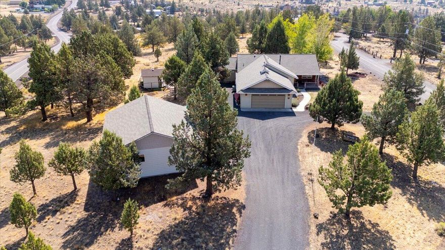 Sitting along the west rim of Crooked River Ranch is this corner lot, stick-built home that offers year-round views of the snow-capped Cascade Mountains. Spend your evenings relaxing on the large Trex deck, taking in the peaceful mountain scenery.
A 30'x37' oversized insulated shop provides abundant shelving, workbenches, and room for all your tools, projects, & hobbies. The easy-care landscaping makes outdoor living easy and with no nearby neighbors, you'll enjoy the privacy you've been dreaming of.
Inside, you'll find an open-concept living area highlighted by custom wood-vaulted ceilings and rich knotty Alder finishes. The cozy propane fireplace creates an inviting atmosphere.
The kitchen features solid surface counters, storage for all of your appliances, and an island with eating space as well as a prep area. This thoughtfully designed home offers 2 spacious bedrooms plus a versatile bonus room—perfect for a home office, or guest space.
