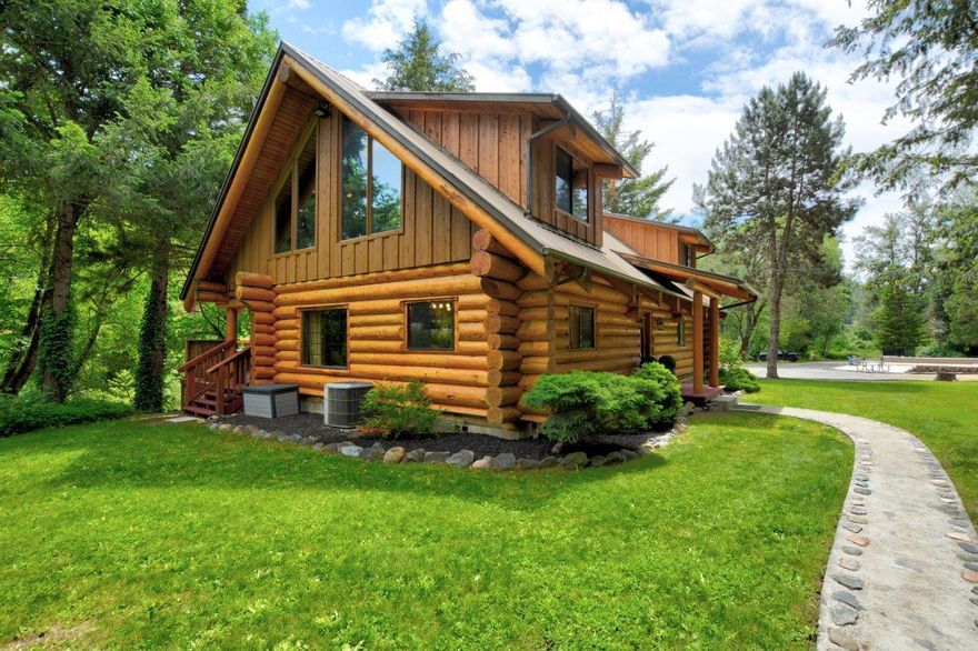 Exquisite waterfront retreat oasis spans over 1500 feet of Evans Creek.  Secluded feel with magical views and perfect for entertaining family and friends both indoors and outdoors!  Beautifully and meticulously updated 3 bedroom, 2 bath log home with exceptional quality throughout. Interior offers a new gourmet kitchen with waterfall granite, farm sink, island, gas range, with porcelain plank tile. Bathrooms updated with custom tile and luxury features throughout.  Outdoor features fruit trees, waterfall into a pond at entrance, newly stained rear deck with an elegant 12x20 gazebo, and hot tub overlooking the water and abundant wildlife. Oversized 3 car garage, 50 amp RV hookup, fire pit, porcelain tile patio, and a regulation size pickle ball court. The immaculate grounds have an underground safety perimeter for pets, along with a private white sand beach, swimming hole, and riding trails. 4.36 acres of irrigation rights make this the ultimate dream home special just outside of town.