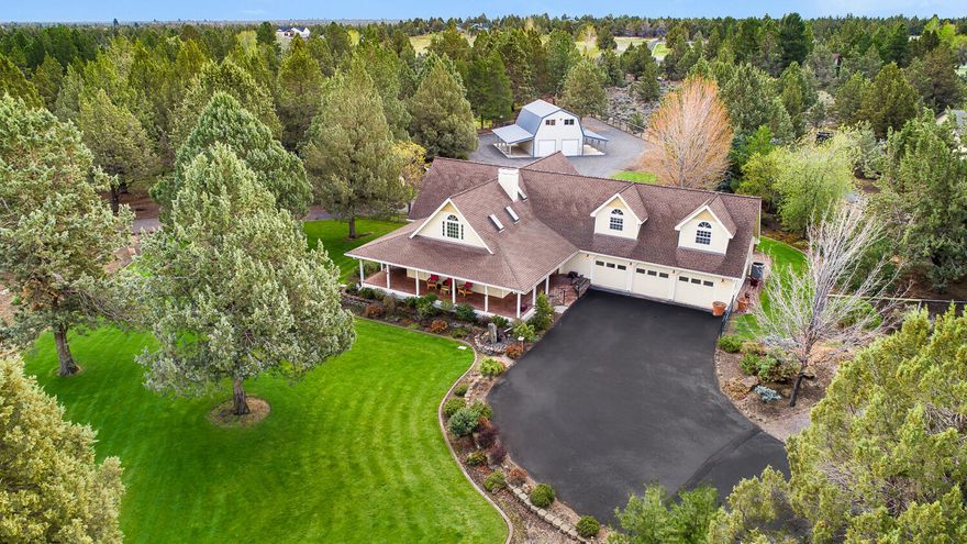 This classic farm style home sits on 2.2 acres with park like fully fenced landscaping. Enjoy the beautiful landscaping, water feature, sunsets, and wildlife from the front deck. The grand staircase is showcased by high ceilings, gorgeous wood beams, and a large rock fireplace. The main level has an office, primary bedroom suite, large living room, dining room, kitchen, and family room area. The chef's kitchen boasts stainless appliances, dual ovens and a large island. The primary bedroom sits at the end of the main level, has a large walk-in closet, dual sink vanity, tiled walk-in shower, and an exterior door leading to the jacuzzi and paver patio. The second level features two spacious bedrooms, a full bath and a large bonus room. An insulated, 1728 sq. ft. shop has an upstairs bonus room and two additional 432 sq. ft. covered storage areas on each side. Landscaping is fed by .5 of an acre of Arnold irrigation using a pond with a water fall & underground sprinklers on timers.