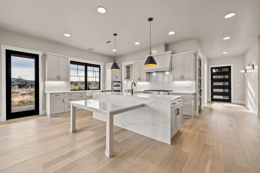 Nestled in the high-desert landscape of Brasada Ranch, this 2968 sqft custom home offers luxury living. The kitchen is a chef's dream with stainless appliances, including a 6 burner Thermador 48'' range, and a built-in fridge/freezer. An oversized pantry with a barn door adds to the convenience, with room for a second fridge. Quartz countertops throughout the home, including a waterfall island with a built-in table, exemplify modern luxury. The formal dining area includes built-ins, and a butler's pantry with a wine fridge. The primary suite features a tile shower, two vanities, space for a stacking washer/dryer, walk-in closet, and a soaking tub. Unique to this home are the high end black Milgard fiberglass windows, a gorgeous laundry room, a junior suite, a built-in bench by the owner's entrance, hardwood floors, Montana mossy rock, tile and wood accent walls, 8' solid stained fir interior doors, and custom cabinetry.
