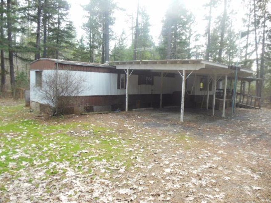 The value is in this beautiful wooded acreage on Laurel Rd. with a mobile home that needs to be either removed or restored. Separate shop building is nice feature. Circular driveway. Marketable timber too. Close to town, but very country feel. Great privacy and place to build custom home.