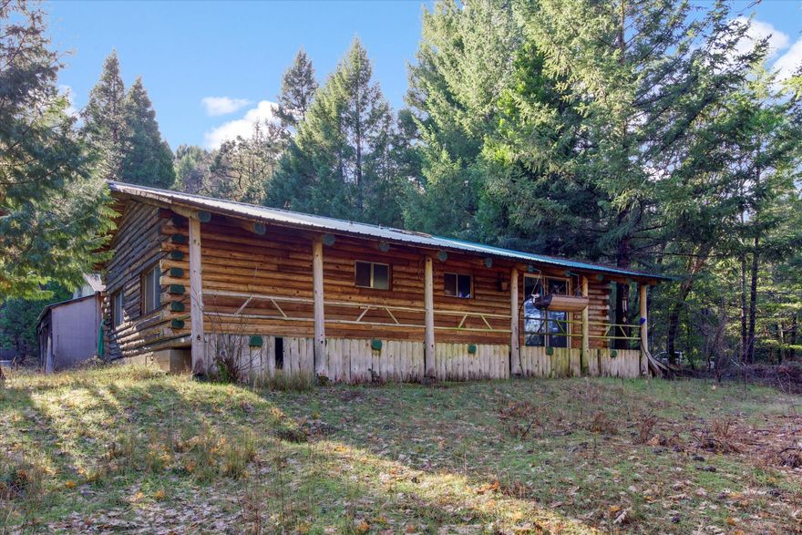 Wonderfully Rustic Log Cabin with 120-acres! Serenely located in a rural area just 13.5-miles from Downtown Grants Pass, this unique property affords both natural beauty and abundant privacy. Originally hand-built and ready for fresh updates, the 2BR/1BA, 880sqft log cabin welcomes with a covered porch, high vaulted ceilings, luminous skylights, wood-burning rock fireplace, a large living room, sizeable windows, a camp-style kitchen, two spacious bedrooms, and a full bathroom with a shower/tub combo. Explore the sprawling acreage to discover a private pond, tons of hiking/walking trails. Little Cheney Creek runs through the property. Hobbyists are sure to enjoy the ample possibilities of the detached 768sqft garage/workshop. Whether you are seeking a secluded retreat or an amazing investment opportunity, this rarely-available property delivers outstanding options. Grid power is a ways away, ideally hydro and solar would be best. Call now to schedule your showing!