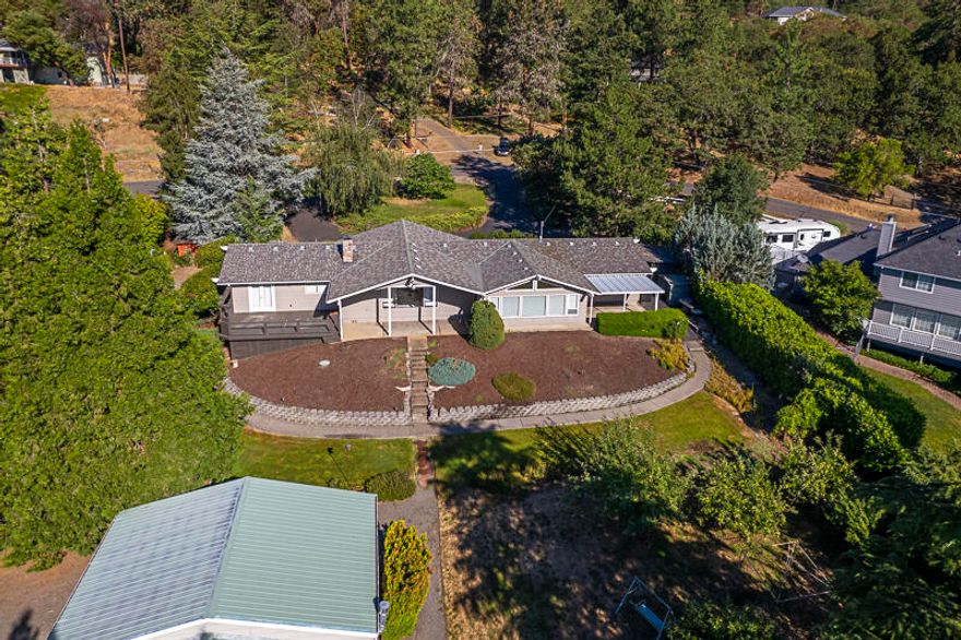 One story home with lots of natural light, ready for your personal touches and updates to make it feel like home, all sitting on almost 1 acre. From the charming breakfast nook to the beautiful sunroom with vaulted ceilings facing views of McLoughlin and the Cascades. Use the space for whatever you desire, a second living room, family room, plant sanctuary, home office or whatever your imagination can come up with. Landscaped with built in irrigation offers many options for outdoor living.  Outback offering 2 covered patios, deck, fruit trees, grapes, with hidden gardens throughout property. Also featuring the very desirable shop area of 1920 sq. ft. with the potential to park many cars or multiple RVs with large roll up doors, this could be a car collectors dream. There is a possible opportunity to add an ADU or convert part of existing structure to ADU. Get the experience of country living while still living in the city of Jacksonville.