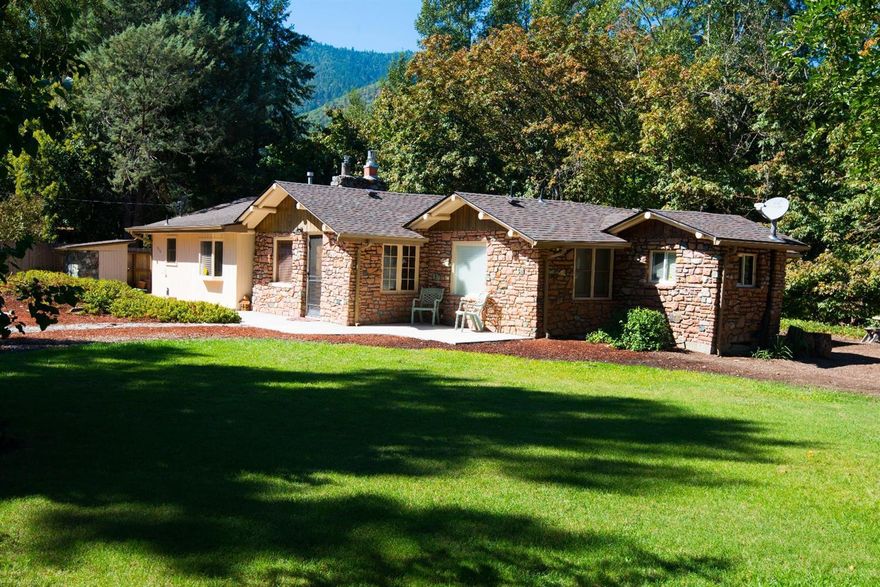 Location Location Location! A rare find in this price range. An updated home on a large lot right on the Rogue River!! SET BACK WAY OFF THE HWY. Lots of room for parking. You have you own BEACH with SWIMMING, BOATING and one of the best FISHING HOLES in the area (per the seller) Salmon or Steel head on the menu tonight, what could be better! The large lot is full of variety of mature trees (Maple, Cedar, Flora, Fauna, Ponderous, Pine, Apple and Fig) and a beautiful expansive yard! This home shows like a model home with amazing natural light, you are ready to move right in. Artistic touches like the log beam ceiling and the custom fireplace made from rare stones, shows the history and charm of this home. The home features a new roof in the last 30 days, a newer laminate floor, feature walls of knotty Pine and beautiful built-ins. 2 wells, one for irrigating and one for domestic water. Buyer to do their own due diligence on all information pertaining to subject property.