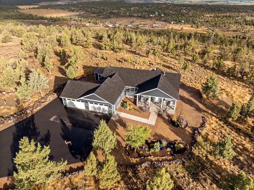 Privately set on nearly 5 acres with low-maintenance landscaping, this reimagined single-level home blends 2019 new construction with complete custom redesign. Guests are welcomed by an expansive covered porch before entering a space where nearly every surface has been elevated with timeless finishes. The gourmet kitchen shines with sophistication with Café appliances and a striking leathered granite topped island. The primary suite, thoughtfully separated from two guest rooms, features a spa-inspired bath with a porcelain tile shower, matching granite countertop, and a spacious California Closets walk-in. Outdoors, enjoy year-round sunsets from the heated TimberTech deck with a Cement Elegance fire pit and sweeping Grizzly Mountain vistas. The entire home was fully repainted inside and out in 2021. The climate-controlled 4-car garage offers epoxy floors and California Closets organization throughout. A turnkey home combining modern design, craftsmanship, privacy & breathtaking views.