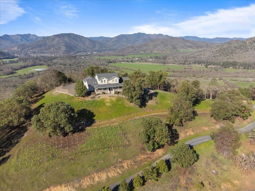 Introducing an exquisite mountain top retreat! Situated on 20 enchanting acres, this property offers some of the most breathtaking 360-degree views in the Rogue Valley. Conveniently located within a 10-minute drive from schools, downtown, & the I-5 corridor, this beautiful spacious farmhouse is a hidden gem. Boasting 4 bedrooms & 3.5 bathrooms, including a main level master suite w/ vaulted ceilings, a private deck, hot tub, & a view that stretches all the way to Table Rock. Not only does this property offer stunning panoramic vistas, but it also comes with a charming 3 stall barn, mini vineyard & a high producing well approx. 33 GPM! Upstairs, you'll find 3 bedrooms & 2 full bathrooms, each providing their own unique views. Expansive wraparound covered front porch, perfect for taking in the tranquil surroundings or entertaining guests. Whether you're seeking serenity, space, or a place to call home, this mountain top retreat fulfills these desires & more.