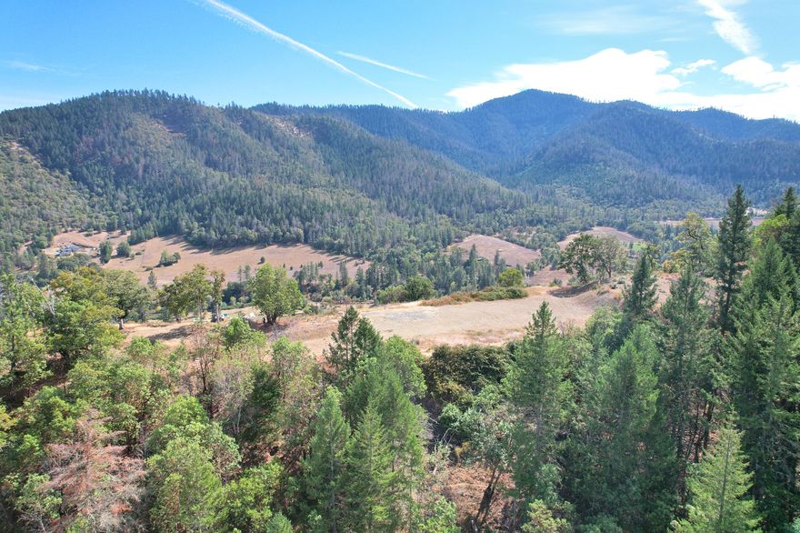 Panoramic Applegate Valley Views! Perched atop a private hill in the heart of the Applegate, this 6+ acres offers a rare opportunity to build your dream estate. Sweeping 270-degree panoramic vistas of rolling farmlands & majestic surrounding mountains. A setting that perfectly blends natural beauty w/ complete serenity. Premier homesite features a large, established building pad w/ two tiers, providing space & flexibility for your custom design. Modern architectural house plans are included, giving you a head start in creating a one-of-a-kind residence. Located at the end of a quiet private road w/ gated entry & total privacy at the home site. A back-side access road through the woods is ideal for peaceful walks & exploring your own retreat. Underground utilities, septic, good producing well w/ holding tank & high potential for solar power. Perfectly positioned, this location offers easy access to local wineries, the Applegate River, dining, shopping & outdoor recreation.