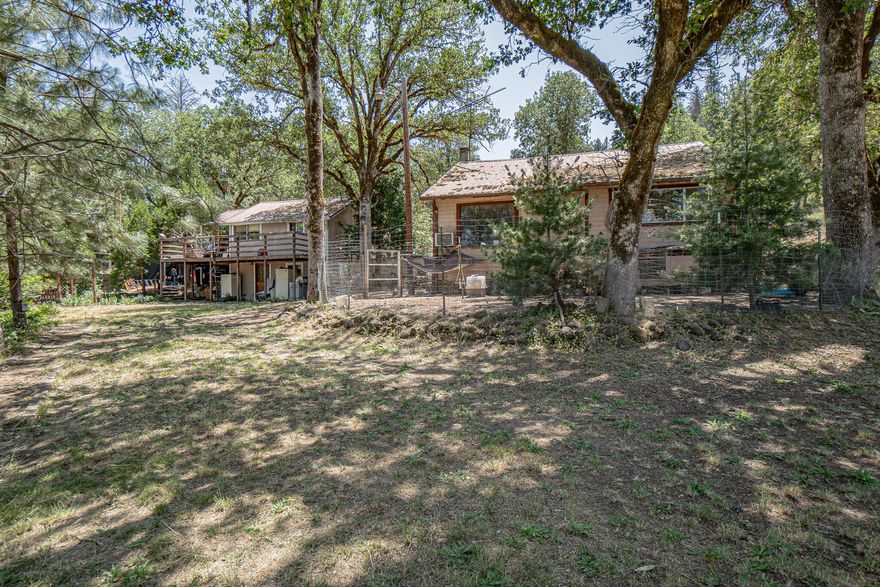 6.62 wooded acres & pasture with 677' of Big Butte Creek! Small house with additional apartment with month to month tenants paying rent of $1,025. New well with 2000 gallon holding tank by Siskiyou pump. Irrigation rights in the past. Buyer to do own due diligence on renewal of rights.