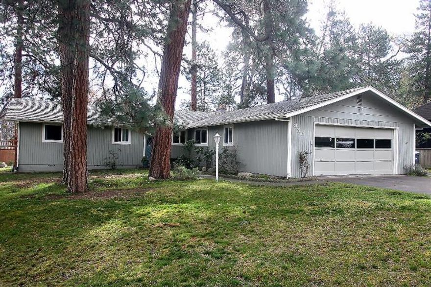 This delightful artistic home is nestled among regal old growth Ponderosa pines on a private .27 acre lot. Large peaceful backyard features a gorgeous custom cedar fence and raised garden beds. Open back patio is perfect to enjoy morning sunshine and cool evening shade in summer. Spacious living room features a cozy fireplace and slider to back patio. Dining area has a slider to access a private covered patio. Large bonus room is currently an art studio and could be an ideal office or den. Kitchen has lots of cupboards and Corian countertops. All 3 bedrooms with new carpet in 2013. Main bathroom has custom tiled shower/floor and Corian counters. Both bathrooms have newer water-saver toilets. All new energy efficient windows and slider doors in 2014. HVAC system replaced and upgraded in 2008. Great storage in oversized 2-car garage. Paved RV parking. Home warranty. Close to shopping, university and schools. Perfect location to enjoy the many hiking & biking trails Ashland has to offer.