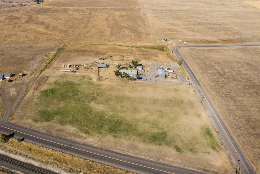 PRICE REDUCED! GREAT VALUE! MOTIVATED SELLER! Spacious 4 bedroom, 3 full-bathroom home with basement. Sits on two tax lots with a combined acreage of 9.18 acres with 8.3 acres of North Unit Irrigation rights. Fenced pasture area in front and back with scenic farm views. Plenty of parking for equipment and other vehicles. Property has several outbuildings including: 24x36 barn, 16x20 multi-purpose shed, and a 25x40 machine shop with lean-to. Irrigation pipes, pump, and trailer included. New rolls of fencing wire and wood posts included. The silver-paneled round pen is included. And Fridge, range/oven, washer and dryer included with sale of home.