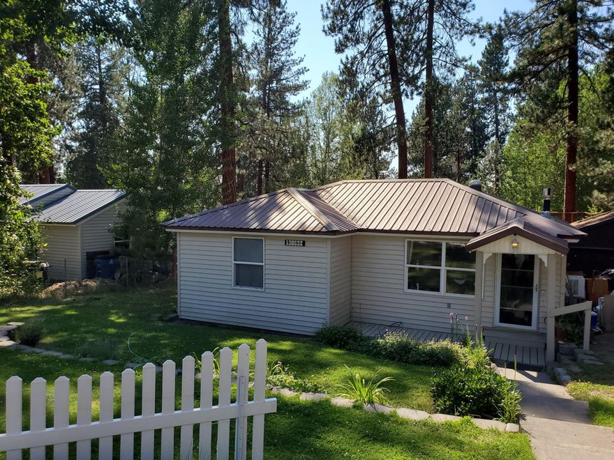 Charming 1 bedroom plus den, 1 1/2 bath home in the Gilchrist Townsite. This home was originally a 2 bedroom. It was enlarged to create a Master Suite.  The kitchen has been remodeled and includes a Jenn-Air range/oven. The range ia gas. The oven is electric. It includes a built in vent. Beautiful back yard with entertaining deck. Feels spacious when you walk in with an open floor plan. Natural gas wood stove keeps you toasty in the winter.  Laundry room includes a half bath. French doors lead to deck. Granite tile countertops. Appliances are included.. Garage is currently used as a workshop/storage. Landscaped yards front and back with welcoming picket fence. Roads maintained in winter. Close to schools, shopping and Gilchrist State Forest. Call for information or to schedule a showing.