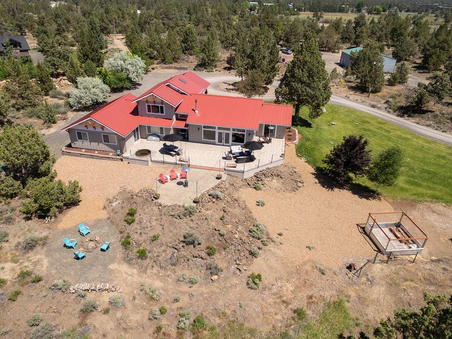 This impeccably renovated home with stunning Cascade Mountains views is just 10 minutes to both Bend and Redmond. The open great room highlights the clean lines of the home, from the oversized cement island to the dining area framed by a wall of windows. Chefs love the double ovens, gas range & abundant custom cabinetry. The office / playroom features a pocket door for taking calls in peace or hiding toys. Multi-generational option or kid haven: the bonus room flanks 2 bedrooms with a shared bath yet separate vanities. A 5th bedroom is used for crafts & music. The main floor en suite is a great alternative for the primary suite upstairs featuring a luxury bath with Japanese soaking tub & gorgeous shower. The extended patio provides al fresco dining and quality time. On nearly 10 acres, 4 acres of 24/7 irrigation creates lush pasture for hay or horses. The 48' x 40' shop, chicken coop, animal stalls & room for more complete the perfect interface between urban style & rural living.