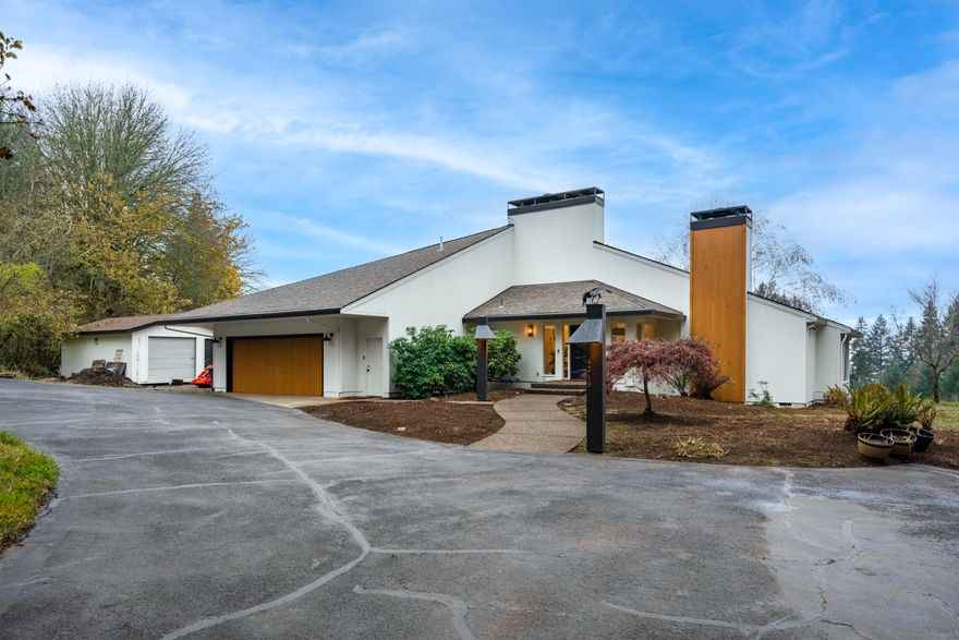 Mid Century Modern classic! Stunning vaulted ceilings throughout main level. Refurbished hardwood floors in LR & DR. Light & bright w/wall to ceiling windows. Gorgeous kitchen remodel w/ SS appliances & tasteful open shelving. Large pantry/laundry combo. Lg primary bedroom w/separate deck, perfect for morning coffee. Dual sinks in bathroom with private sauna. Lg bonus/movie room on lower level. Secret sliding door to a potential speakeasy or wine cellar. Outside features raised garden beds & heated shop!