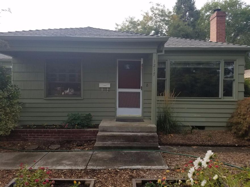 Urban Retreat! Pull into your driveway and enter into your own green space. A 50's era home on beautiful .18 acre lot with alley access. This is a solid, well maintained home with 1 car garage as well as a separate, detached carport/shed with alley access. Great property for gardeners with mature plants & flowers in front and backyard along with a large vegetable garden. Original hardwood floors throughout much of the home. Efficient wood stove for cozy winter nights and bonus room which makes a great 3rd bedroom or master.