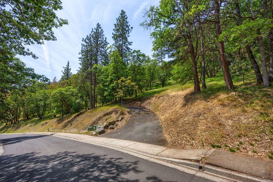 This exceptional residential lot offers sweeping views and a rare opportunity to build in one of Ashland's most desirable neighborhoods. Just minutes from Downtown Ashland, above Lithia Park, and steps from scenic hiking trails, this property places you in the heart of Ashland's natural beauty—where theater, outdoor adventures, and fine dining meet. Surrounded by custom homes and adjacent to over 4 acres of protected open space, the lot includes an approved building envelope and potential for both a main residence and an accessory dwelling unit. A recent professional site evaluation outlines development considerations and offers guidance for working within hillside standards and city requirements. This is a unique chance to design a custom home in a FireWise community known for its moderate climate, vibrant culture, and unmatched quality of life. Site evaluation available upon request.