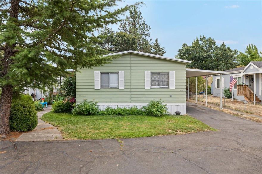 Do not miss the chance to make this beautifully kept manufactured home yours. Located in an all age park on the peaceful countryside of Central Point while still being close to town, this 3 bedroom 2 bathroom home has the perfect mix of comfort and functionality with a spacious split floor plan. The kitchen features modern cabinetry and plenty of counter space, perfect for cooking and entertaining. A wood stove adds a warm and cozy touch to the living room while large windows fill the space with natural light. Plus, the home now has a brand new mini split system to keep you comfortable year round. Step outside and enjoy the covered front porch for your morning coffee or evening sunsets. The oversized carport fits up to three vehicles, and the large storage shed gives you extra space for tools, toys, or hobbies. The yard has room to garden, play, or simply relax and enjoy the peaceful surroundings. Homes like this do not come up often in this area, so schedule your showing today!