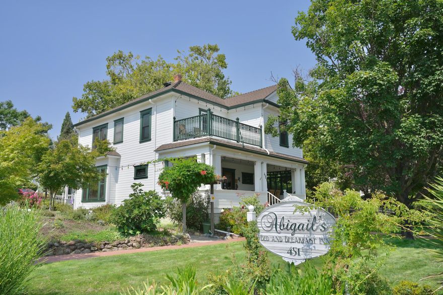 Located just blocks from downtown Ashland, this elegant property presents a turnkey opportunity for lodging or hospitality investors. Thoughtful modern upgrades enhance original woodwork, floors, and high ceilings, blending historic charm with contemporary convenience. Guests are welcomed by a manicured lawn, pollinator garden, and inviting front porch. The main level offers a spacious living area and kitchen, plus a private suite with exterior entrance and the owners 1 bedroom, 1 bathroom apartment. Upstairs, four ensuite bedrooms provide privacy and comfort, one with a balcony. A detached 700 sq ft, 2 bed, 1.5 bath cottage with its own address and electric meter adds income potential. With ample off-street parking, this versatile property is ideal for a thriving B&B, boutique rental, or extended-stay model. Whether expanding your portfolio or entering the hospitality market, this distinctive property is ready for its new proprietor.