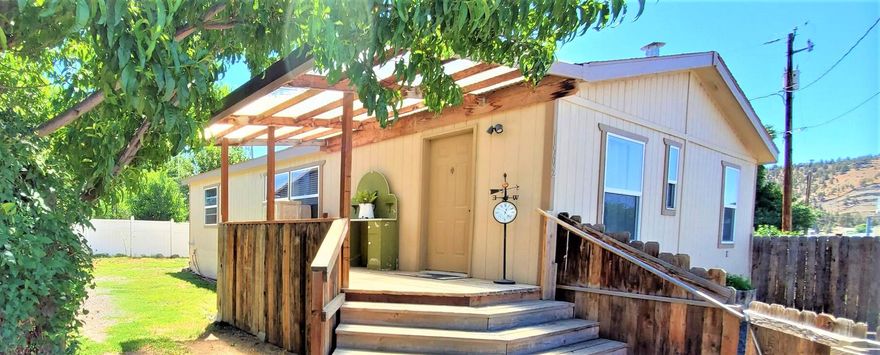 Darling home nestled back with large detached garage. Home features 3 bedrooms, 2 baths and laminate flooring throughout, vaulted ceilings and open floor plan. Primary bedroom located opposite end away from other bedrooms, adding extra privacy. Front and back porches are great places for visiting friends and family BBQs. Garage has full bathroom, with new hot water heater and area for guest room as well as additional storage and workshop areas. Property is fenced with mature fruit trees, adding nice shade. There is an RV hookup on side of garage. Additional storage shed with power for even more storage options. Located not far off of Madras Hwy., this property is zoned General Commercial, allowing for a business venture. Buyers to check with Prineville City for complete property use options.