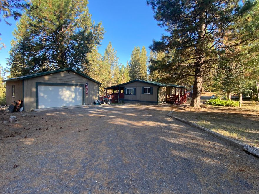 Beautiful Home in the pines! Just minutes to Hwy 97. This 2 bedroom, 2 bath home features Pine Kitchen Cabinets, A Propane gas log stove, 4.84 acres completely fenced, Beautiful back deck, nice size back yard also fenced, a detached 2 car garage with concrete floor, Metal roof and a covered front porch. Some landscaping making this a very peaceful setting!