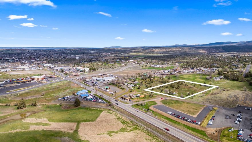 Opportunity to develop 4.45 acres of commercial land is available! MUE zoning allows for many uses, including manufacturing and production. Homes on the property have been removed.  Has road access and high visibility from HWY 97. Uncover the possibilities this property has to offer. Call an agent today!