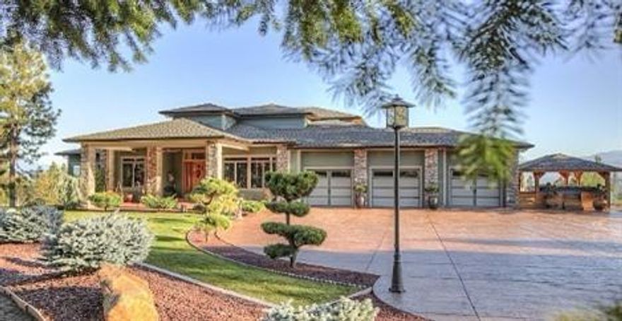 Leave your cares behind as you enter the private gate to this exquisite property. Attention to detail is apparent from the moment you enter into over 6000sf of luxurious living space with expansive hardwood flooring and soaring ceilings. Custom kitchen with marble counters, large island & custom cabinetry and opens into the grand family room. Separate living room and formal dining room with Butler's Pantry. Large master suite on main level has fireplace, private deck & incredible views. Well appointed master bath includes jetted tub, double vanity, water closet & large enclosed shower. Two bedrooms with Jack-and-Jill bath all on the main level. Step out of the family room into a 720sf sun-room with stunning city views. The enormous upstairs has a gas fireplace, wet bar, and covered balcony with picturesque views. Lower level with living room, 4th bedroom, bath, & additional living space. Finally, the detached 5000sf insulated shop w/ 220 power for all of your projects & hobbies.