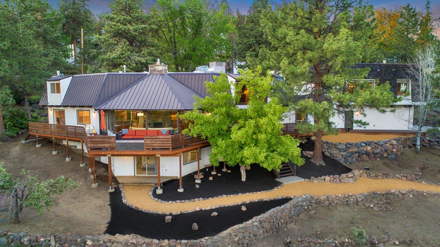 Situated in the West Hills of NW Bend on a 1/3 acre corner lot offering privacy while maximizing panoramic views that stretch from Mt. Bachelor, Paulina Peak, Old Mill smokestacks & of town. The main home is 3003sf plus a fantastic 1033sf guest quarters. Completely renovated & purposely designed to maintain the home's character, including rock fireplaces, original clear cedar strip paneling, & tongue and groove pine ceilings w/exposed beams. The primary suite is on the top floor with views of Mt Bachelor from bed. The main floor offers floor-to-ceiling windows, a stunning kitchen, bar, custom wine room, dining room, laundry, a bedroom, & two living areas with fireplaces. The loft is ideally suited for spectacular views, working from home, or an extra getaway space. The lowest level offers a private suite, w/interior & exterior access. Outdoor living spaces include a South-facing front deck w/built-in BBQ & custom gas fireplace, a rooftop patio, a back patio & yard, & lower deck & yard.