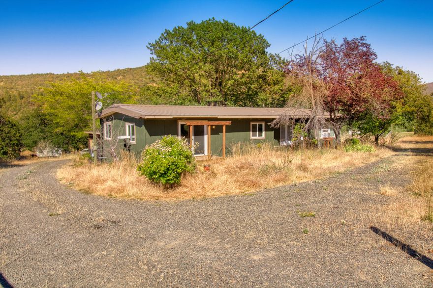 Discover your peaceful and private home in the heart of these rolling hills with a charming 1975 manufactured home on 4.05 acres. With 2 bedrooms and 2 baths, 4611 was recently updated with a new kitchen, and floors throughout.  Step out onto the newer back deck, which offers a perfect spot to take in the tranquil views of the surrounding countryside and enjoy the open flat acreage. Conveniently located just over 10 minutes from Eagle Point and near the Stone Ridge Golf Club and Agate Lake, you'll have plenty of opportunities to explore the great outdoors. With a great well that produces over 16 gallons per minute per well flow test, you can be assured of a reliable water supply. For creditworthy buyers, the owner is willing to carry, making financing a breeze. Don't miss out on this opportunity to own your own piece of paradise in the serene countryside