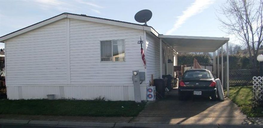 Great double-wide manufactured home located in a family park. The home has an open floor plan with lots of living space. Vaulted ceilings and lots of natural light add to the spacious feel. The park is central to Medford city services and parks. The Master bed and bath are separate from the two guest bedrooms and bathroom, to give privacy. The kitchen has lots of open counter space and storage with a nice island for convenience. The landscaping is designed to be easy to maintain.