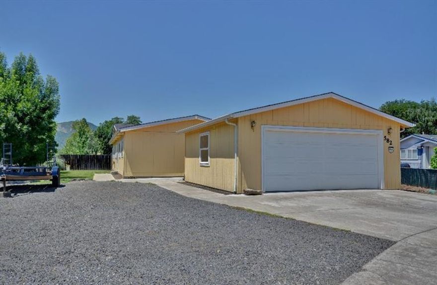 Affordable family home now available! Beautiful Views of surrounding hills from this four bedroom, two bath manufactured home built in 2001 on its own .17 acre lot! Features include open floor plan, vaulted ceiling, ceiling fans, large kitchen, and indoor laundry room with lots of storage. Security System, New Carpet in Bedrooms, Laminate flooring in Kitchen, Dining and Living Room. This home also has a large fenced yard with in-ground sprinklers. A detached two car garage with 220, built in work bench and shelving. RV parking with clean-out and lots of additional parking.Not a short sale or foreclosure...just ready for you to call home!