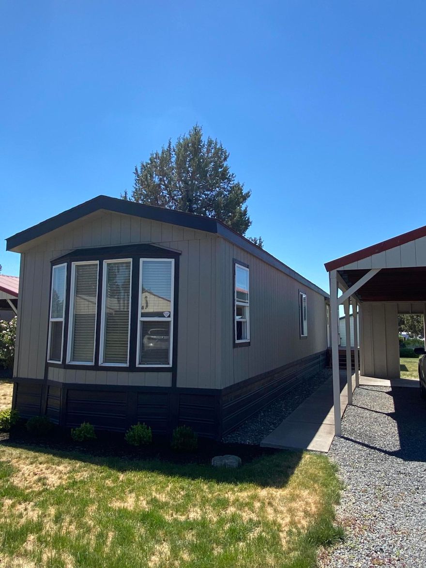 Tidy and well kept move in ready home.  Large bright kitchen with dining area, great cabinet space with pantry.  Nice sized corner lot with double carport and lockable storage shed.  Mountain views from covered back deck.  Home has a newer roof, new heat pump, new decking, recently painted, newer flooring.   Quiet  and well maintained 55+ park.  Must get park approval.  Close to airport, stores, parks and trails. RV parking may be available for additional fee, inquire with park manager.