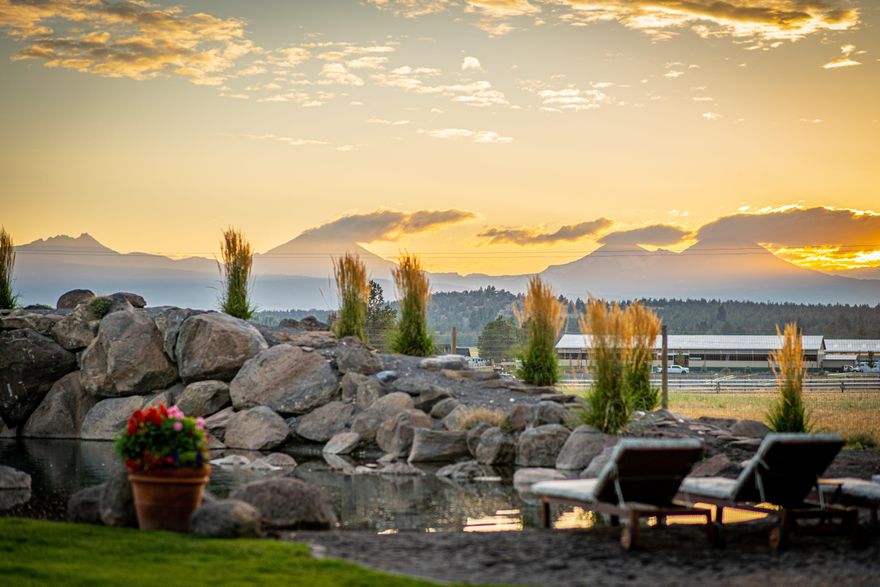 This magical property is situated in the heart of Tumalo on 23.46 acres. A swimming pond with a natural rock diving board is surrounded by a fenced garden, vintage European greenhouse and lush landscaping .Stunning views of the  Cascade Mountains from the home and property. The main house has beautiful reclaimed barn wood floors, updated kitchen and main level primary, wood burning fireplace. The home had a large remodel to include a mud room, laundry room, office, bedroom and den.  The property features several out buildings including storage barn (60X100), 5 stall barn, 4 stall barn with corrals, greenhouse (30x100), equipment storage (40X50) and a charming sleeping cabin. There are 20 acres of water rights that convey with the property. The possibilities for this serene property are endless!