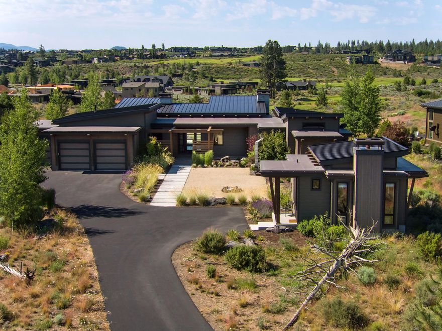 Take in the incredible mountain views and luxury resort living in this single-level modern home in Bend! With a spacious, open floor plan and natural light throughout, the contemporary design and impressive finishes, including white oak floors, exposed beams, Board form concrete walls & wood burning fireplace, hold both a peaceful sanctuary feel as well as perfect gathering spaces. The gorgeous primary suite is complete with access to the covered patio with expansive views and outdoor gas fireplace. On the opposite wing, the additional bedrooms, all with en suites, will offer all of the overnight quiet and privacy desired. Large office in the main home and the added detached casita are ideal remote workspaces, home dens, or studies. Low maintenance landscaping surround this gorgeous house located in the gated cul de sac community in Tetherow that borders the Deschutes National Forest, with perfect indoor and outdoor areas for your Central Oregon living experience at its very finest
